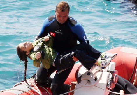 A diver carries a young girl, after a boat carrying illegal immigrants trying to reach Europe capsized in waters off western Turkey, on September 6, 2012 near Izmir. Forty-five people including two crew members were rescued alive, and at least 39 people drowned. The captain and his maid who were among the survivors were detained. AFP PHOTO / IHLAS NEWS AGENCY **TURKEY OUT**